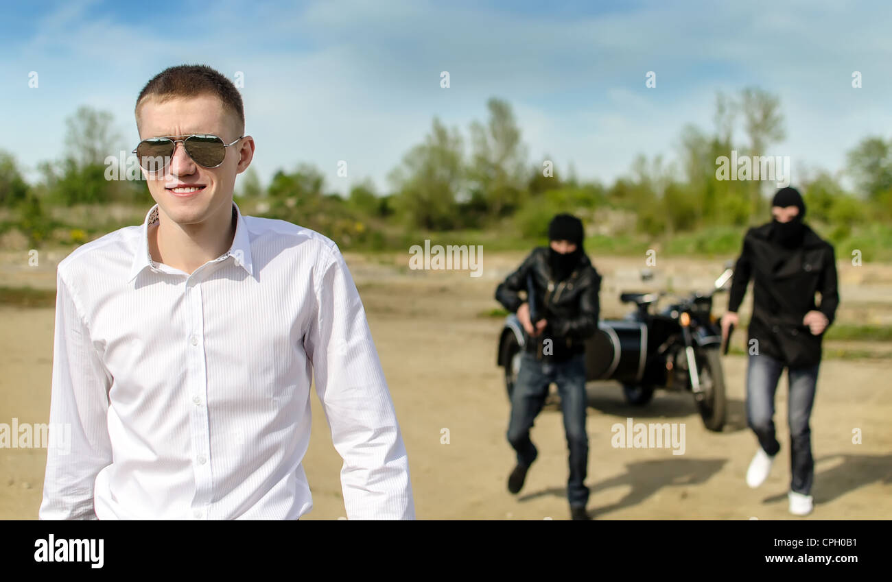 Zwei Banditen entführt einen Geschäftsmann mit einem Koffer Stockfoto