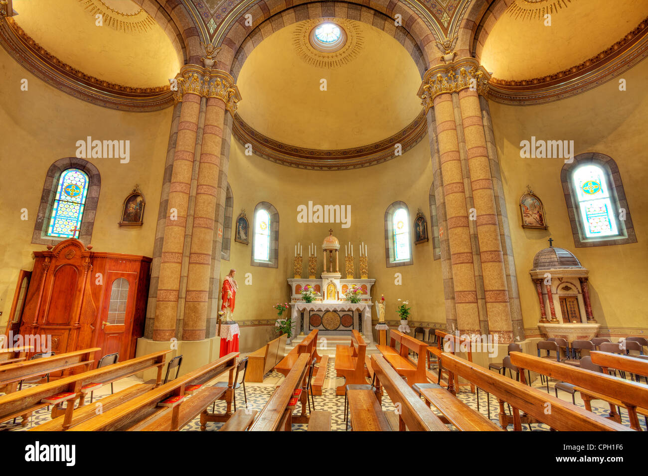 Bänke und Altar zwischen den Spalten in Madonna Moretta katholische Kirche in Alba, Italien. Stockfoto