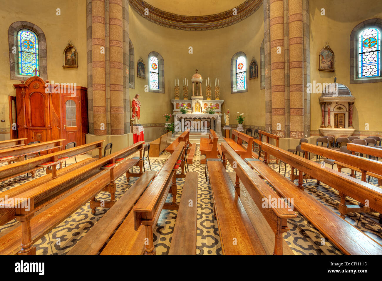 Bänke und Altar zwischen den Spalten in Madonna Moretta katholischen Kirche in Alba, Norditalien. Stockfoto