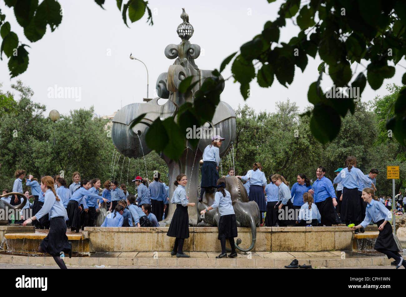 Gruppe von jüdischen ultra religiöse Schulmädchen spielt in einer Stadt-Wasser-Brunnen. Jerusalem. Israel. Stockfoto