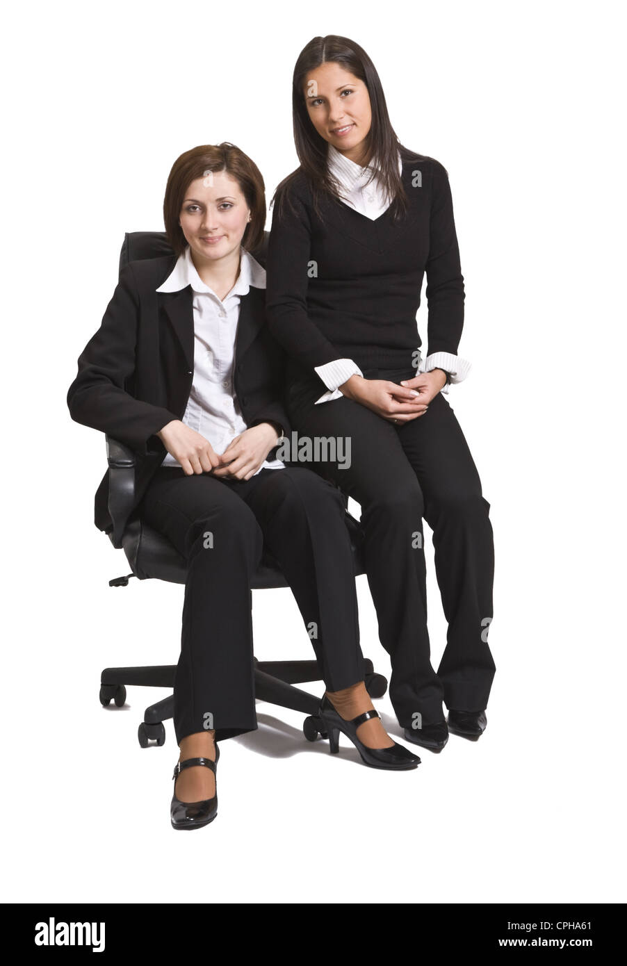 Zwei junge Unternehmerinnen Kollegen sitzen auf einem Stuhl vor einem weißen Hintergrund. Stockfoto