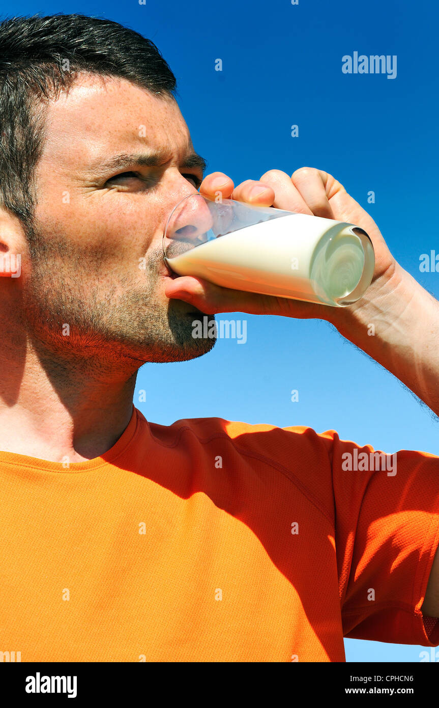 Mann ist in der blauen Skye frisches Glas Milch trinkt. Stockfoto