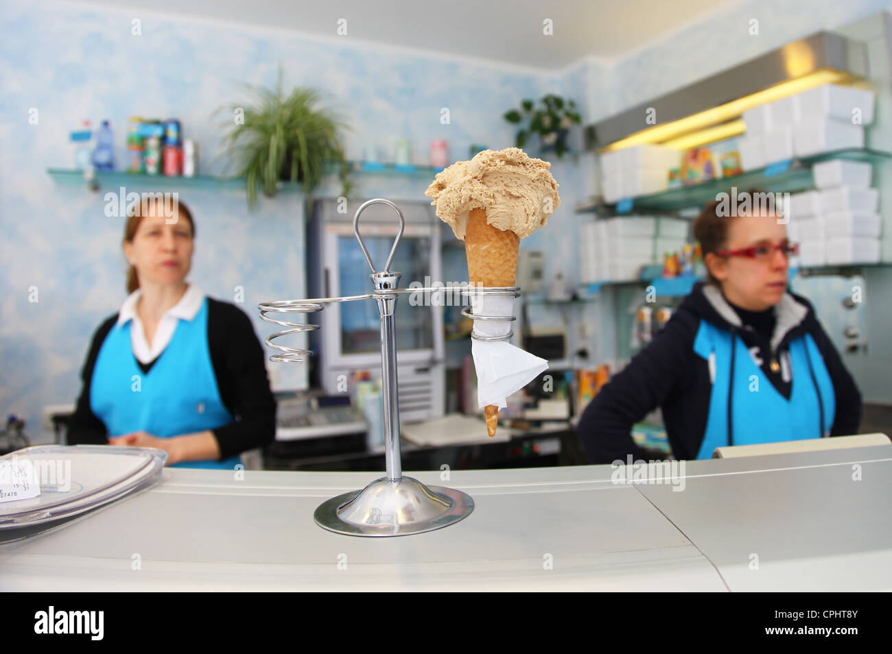 Eine italienische Eisdiele oder Gelateria serviert eine Eiswaffel oder Kornett in einem Stand auf der Theke Stockfoto