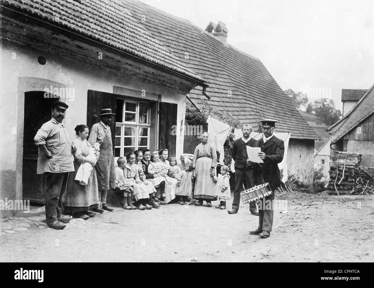 Stadtausrufer inmitten einer Bauernfamilie Stockfoto