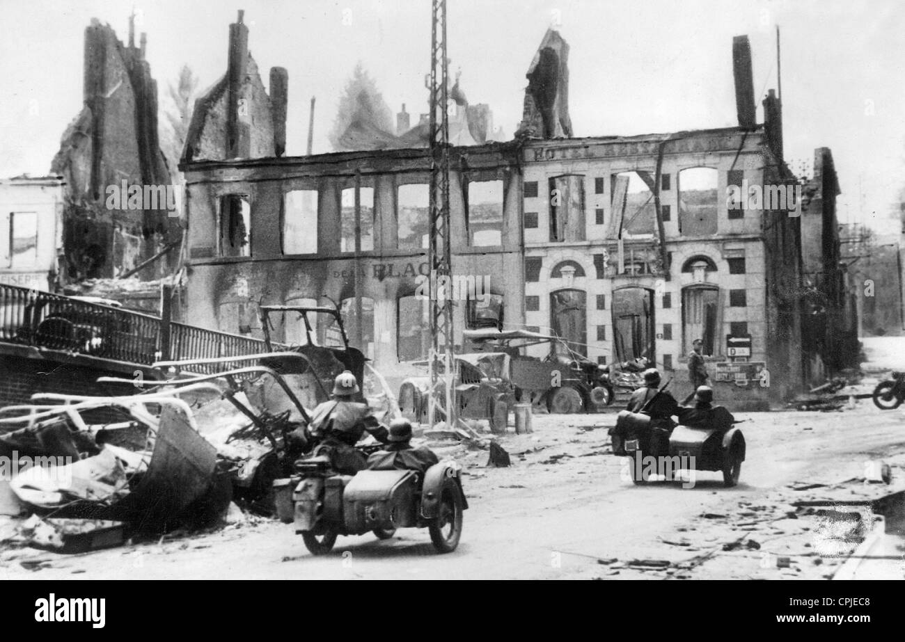Eine deutsche Motorradeinheit in einer zerstörten Stadt Französisch, 1940 Stockfoto