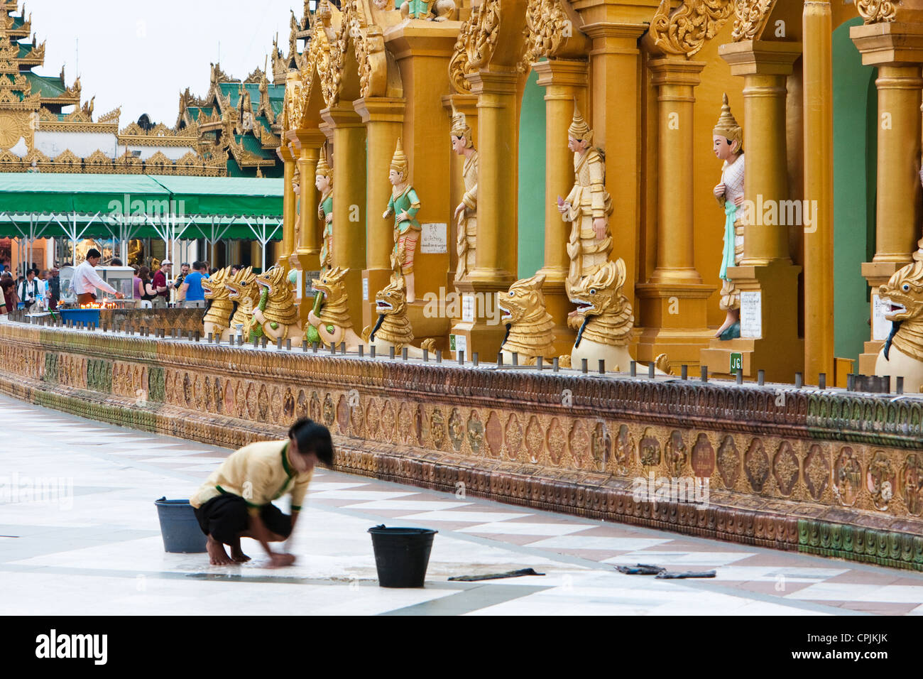 Myanmar, Burma. Shwedagon-Pagode, Yangon, Rangun. Freiwilliger Arbeiter Reinigung des Bodens des Hofes. Stockfoto