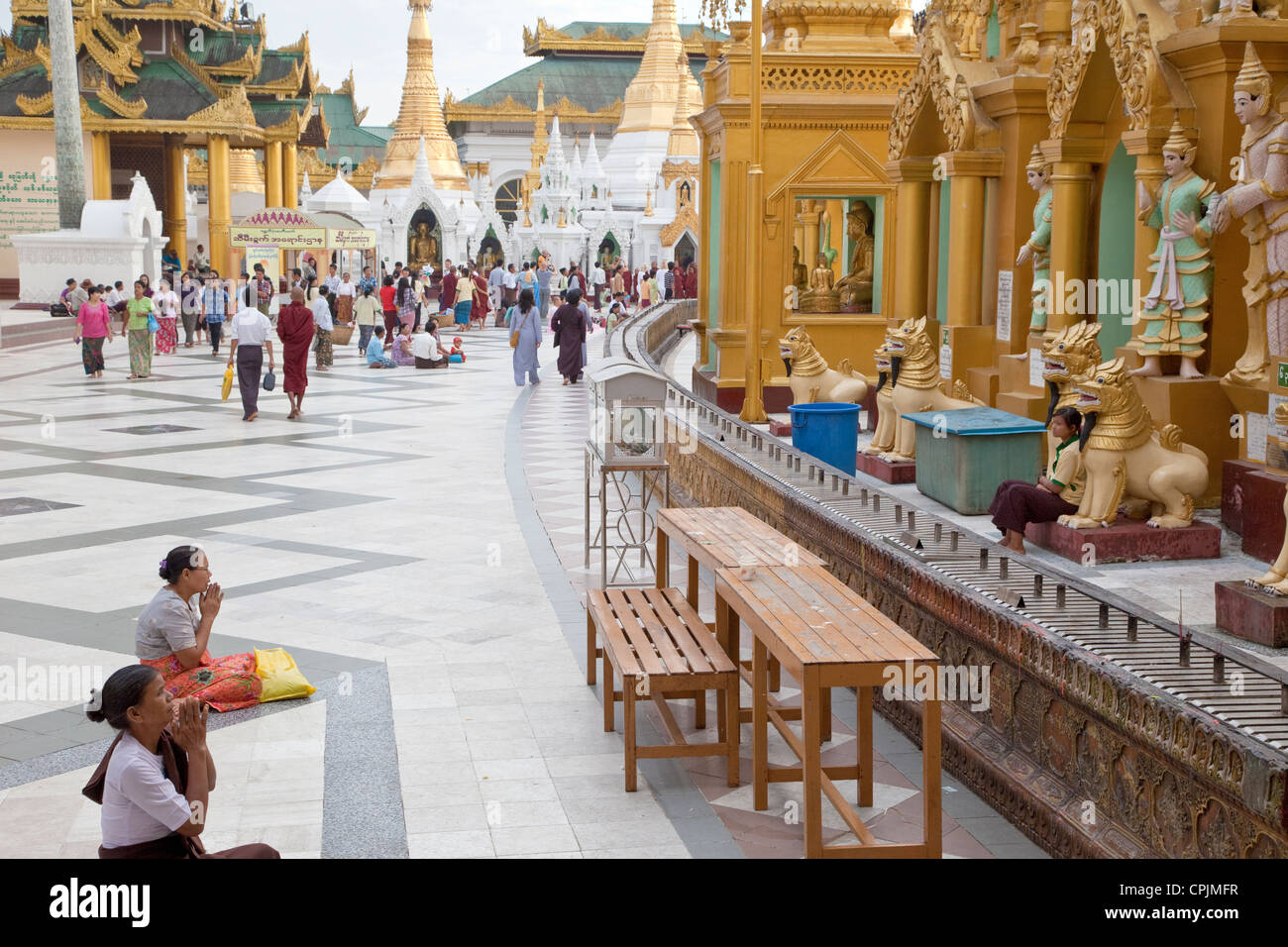 Shwedagon-Pagode, Yangon.  Frauen beten zu Nats, verehrt buddhistischen Geistern in Myanmar, als Besucher umrunden die Stupa. Stockfoto