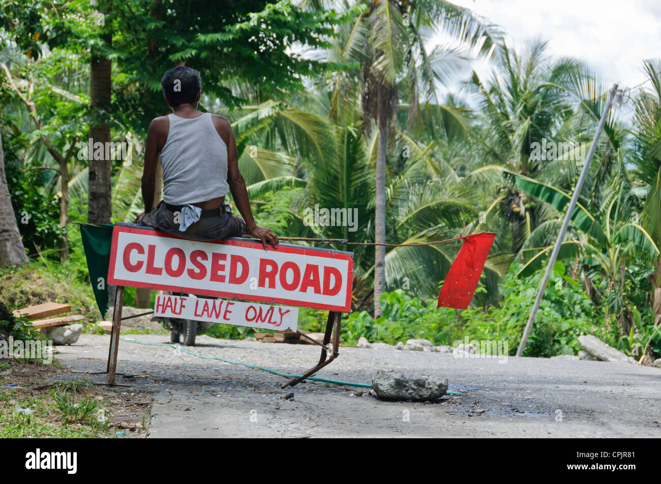 Braungebrannte asiatische Straße Arbeiter rote Fahne Straße arbeitet Baustelle im Dschungel - Sabang Oriental Mindoro Philippinen Südost-Asien Stockfoto