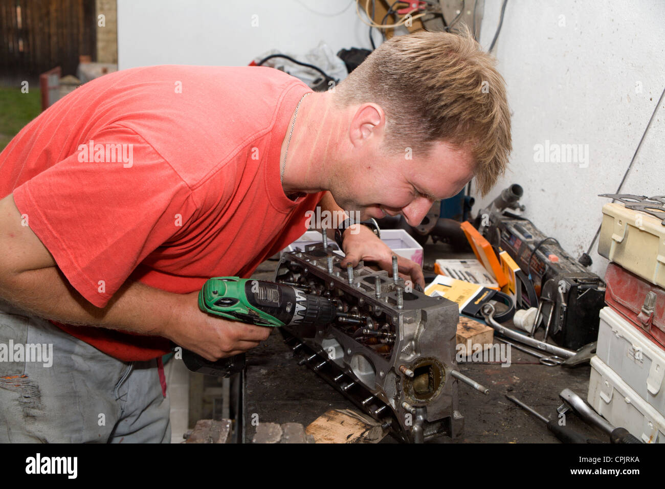 Lächeln des Mannes bei der Reparatur der motor Stockfoto