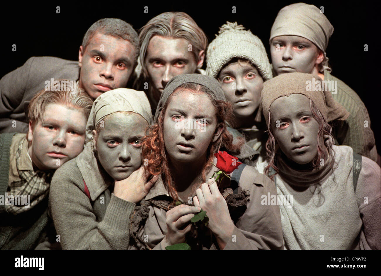 Eine Gruppe von jungen Schauspielern mit grauen farbigen Make up durchführen "Grau Menschen" mit einer einzelnen roten Rose Stockfoto