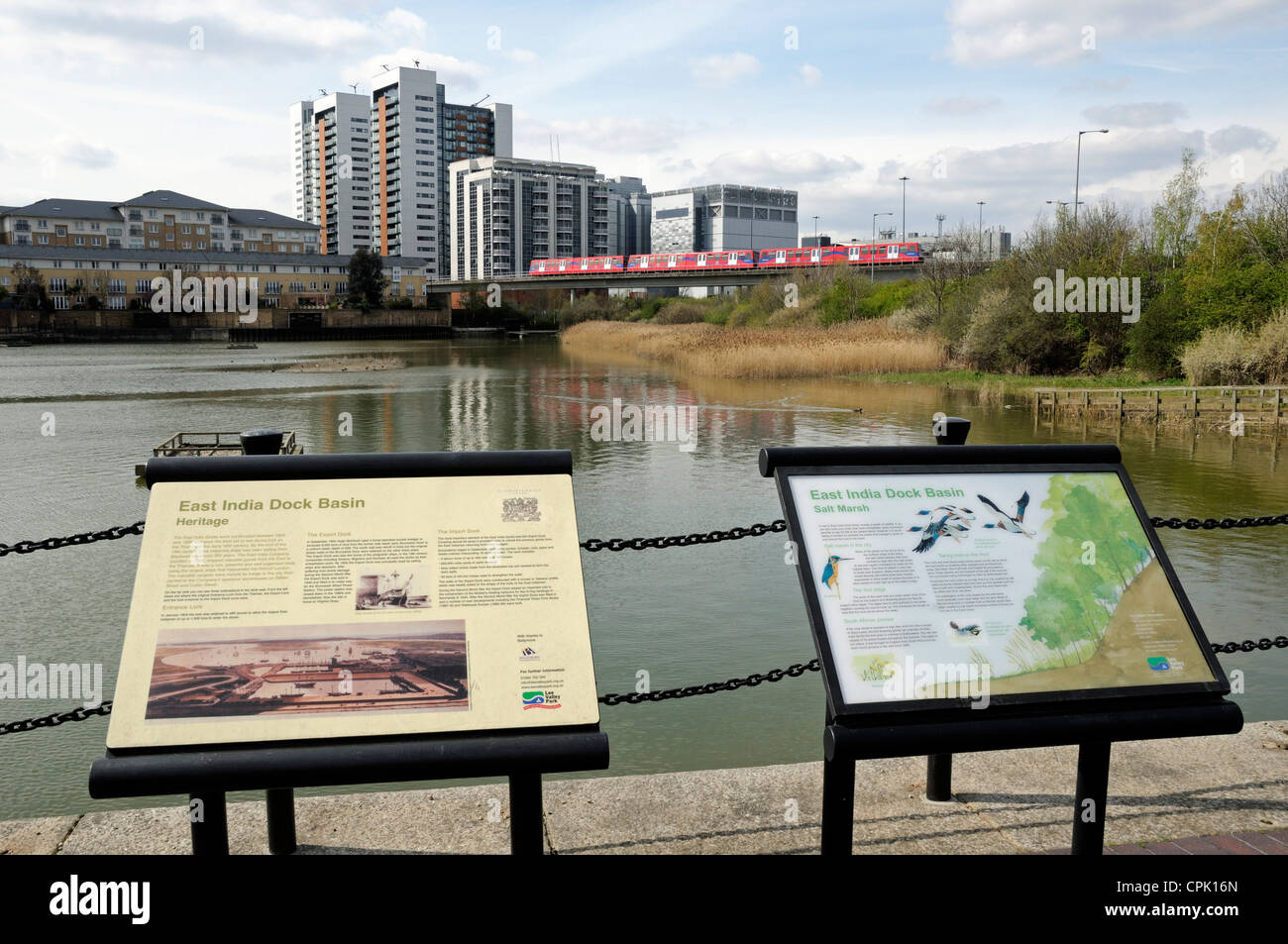 East India Dock Becken nun eine urban Wildlife reserve interpretativen Bretter in Forground und DLR Zug Kreuzung Leamouth Peninsular Stockfoto