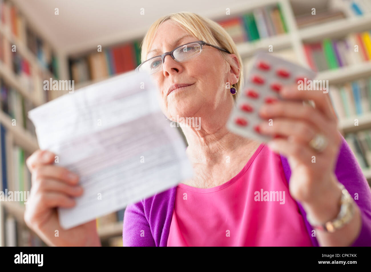 Kaukasische Seniorin mit Medizin und Arzneimittelverordnung lesen. Niedrigen Winkel Ansicht Stockfoto