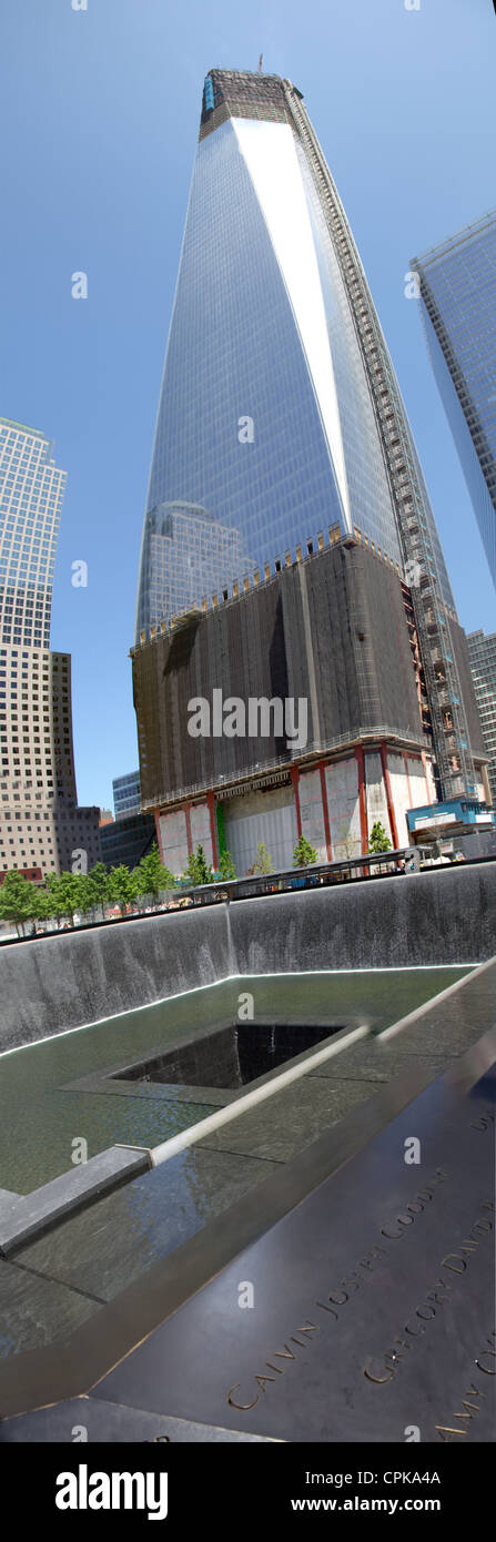 9/11 Gedenkstätte am Ground Zero, Wasserfälle mit Namen eingeschrieben um Rand derjenigen starb, New York Manhattan Freiheitsturm hinter Stockfoto