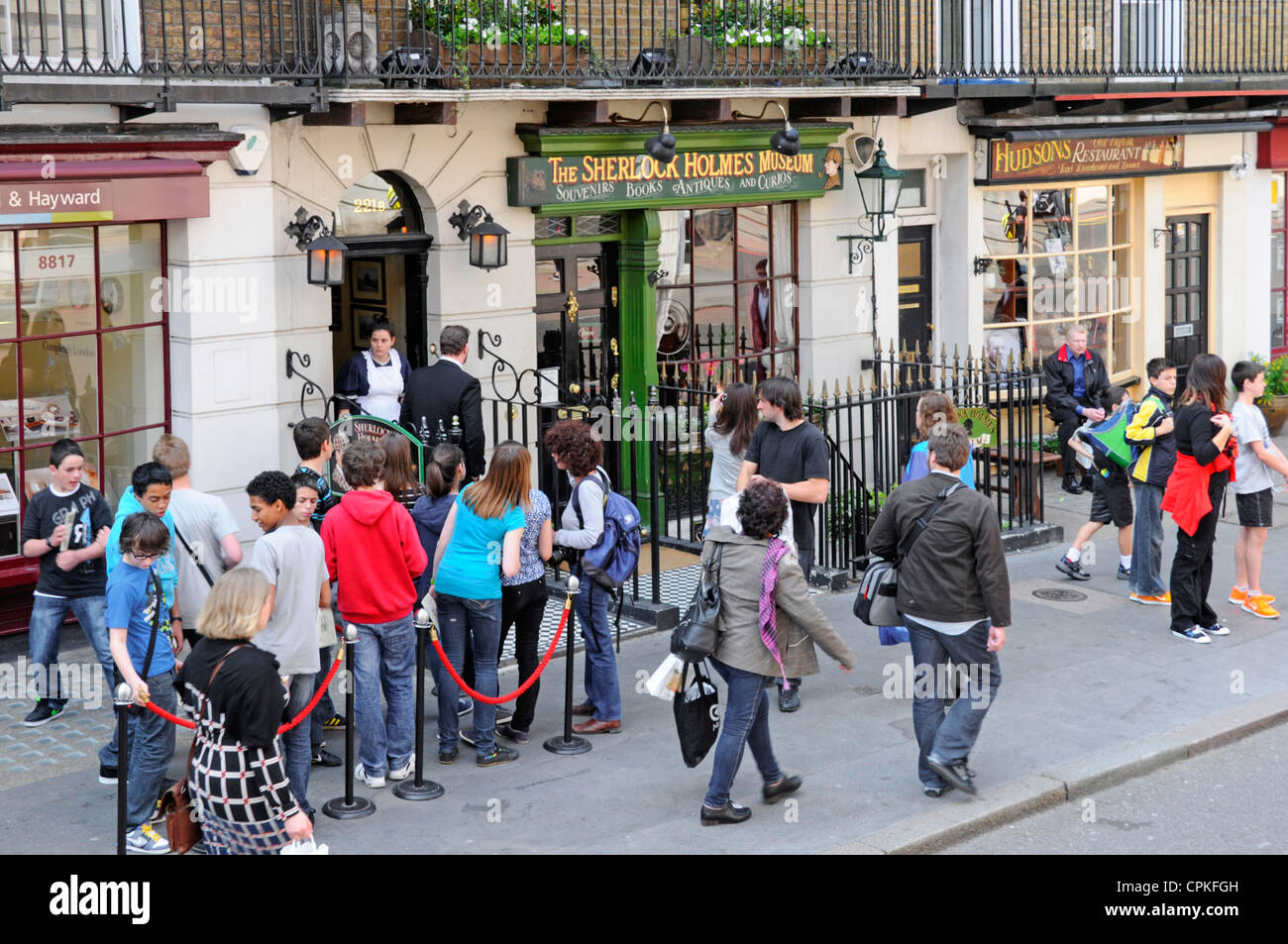 Blick von oben auf das Sherlock Holmes Museum Gruppe von Schulkindern auf Pflaster hinter Seil Barriere 221B Baker Street London warten Stockfoto