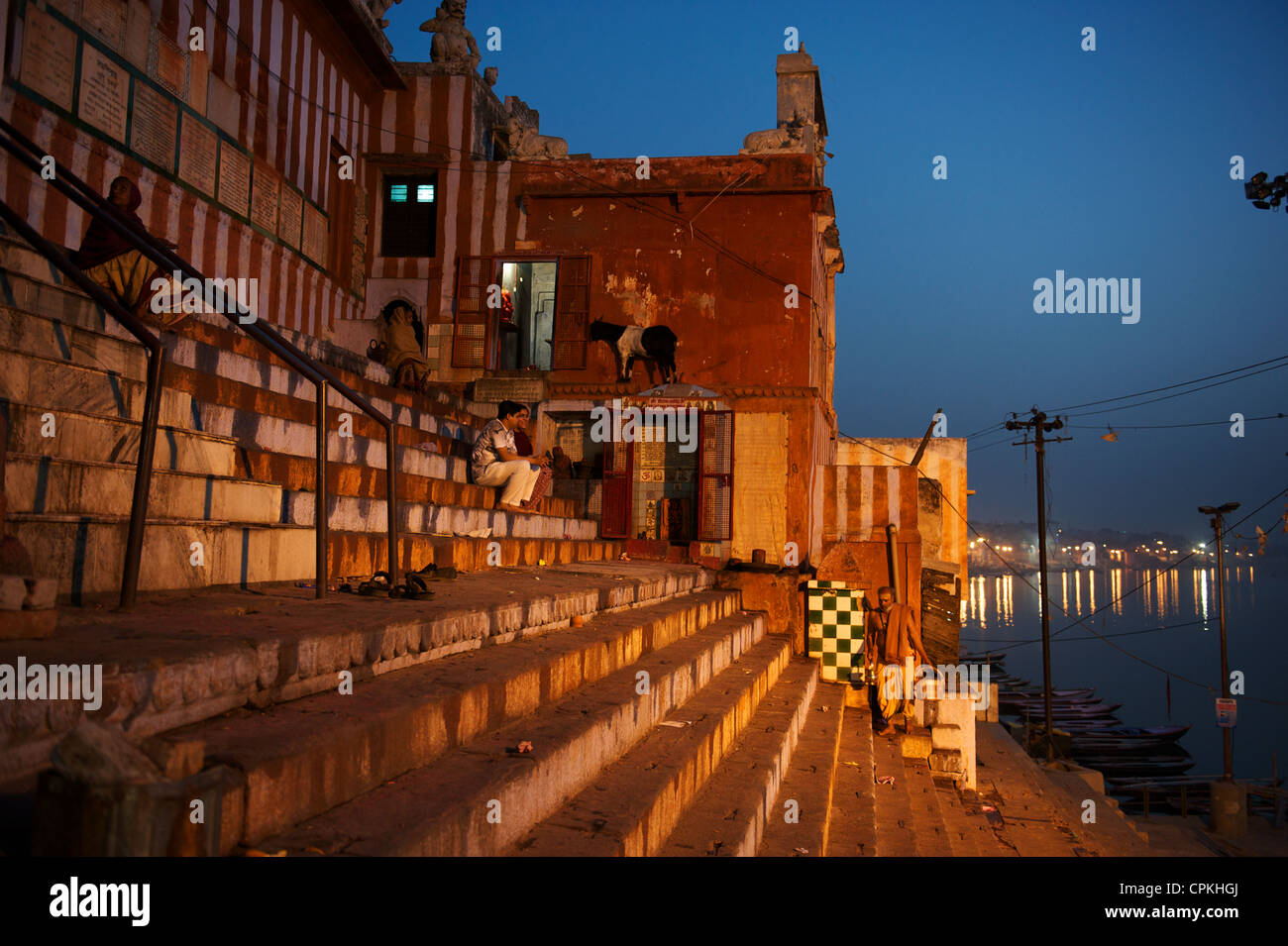 Beim Sonnenaufgang über dem Ganges gebadet werden die Ghats in warmes Sonnenlicht, Varanasi, Uttar Pradesh, Indien Stockfoto