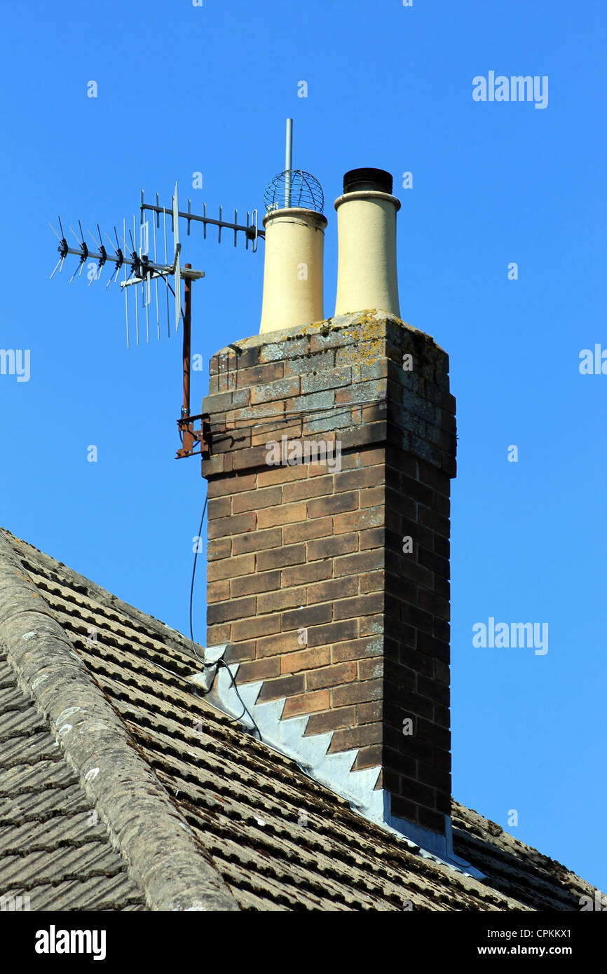 Schornstein auf Ziegeldach mit Luft, blauer Himmelshintergrund. Stockfoto