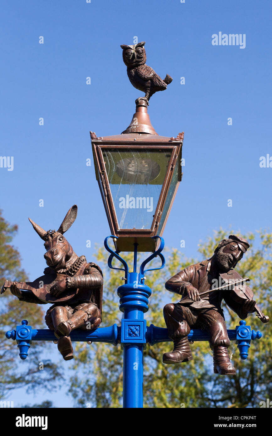 Laternenpfahl in Stratford-upon-Avon Darstellung unten, eine Eule und ein traditioneller jüdischer Fiedler. Stockfoto