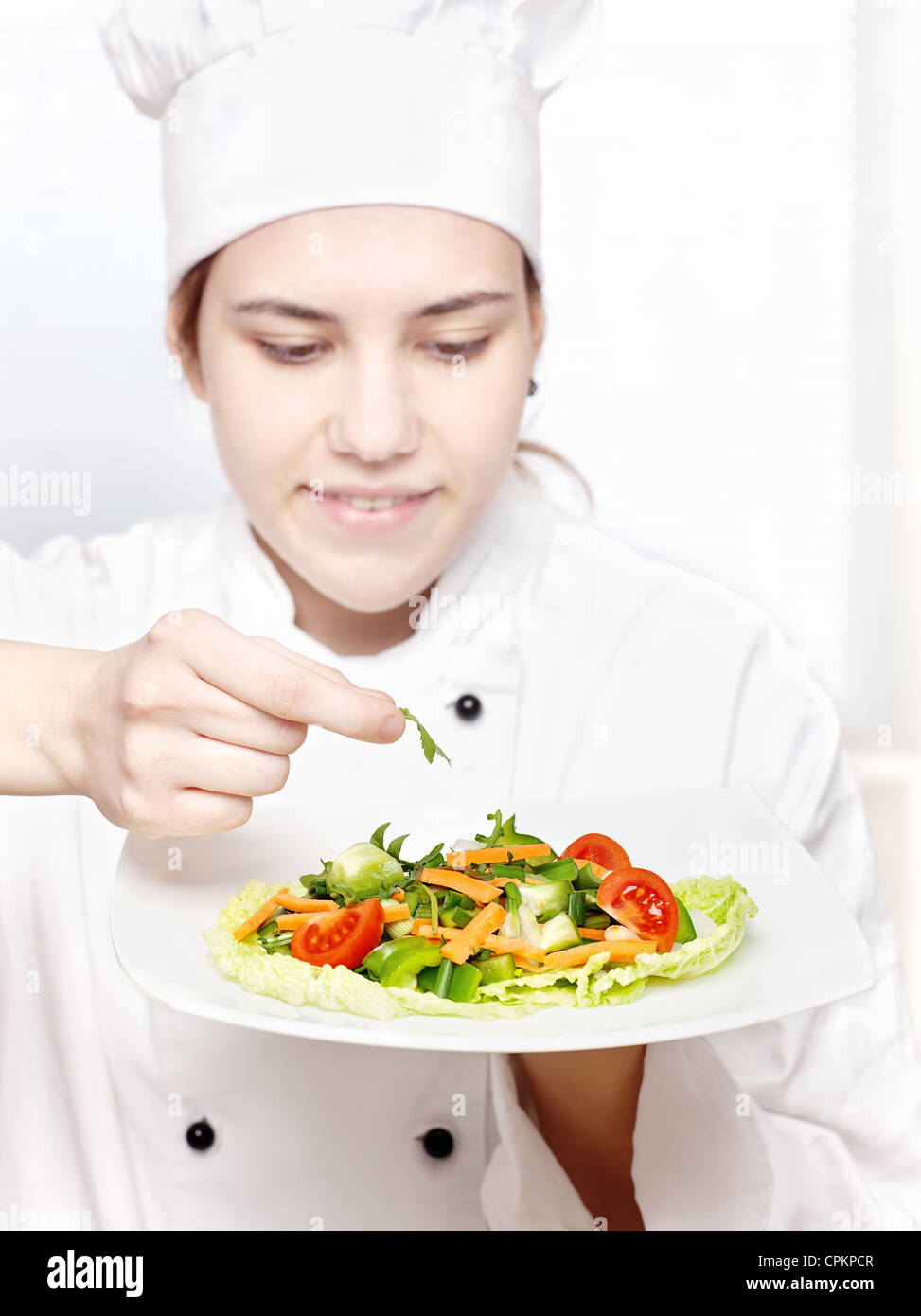 hübsche junge Küchenchef köstliche Salat dekorieren Stockfoto