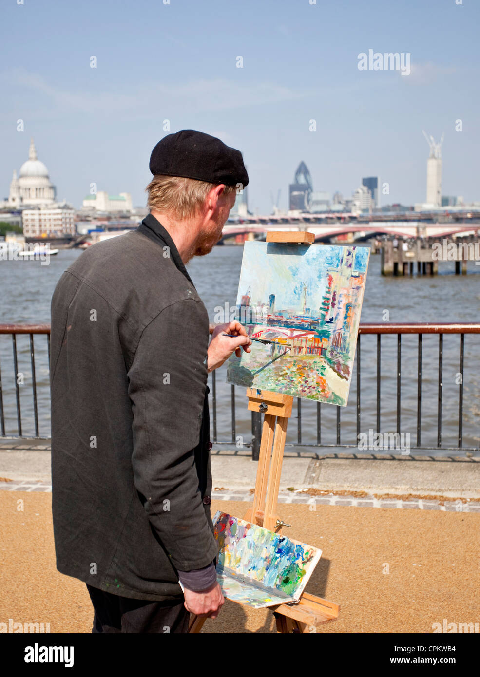 Hinten zu sehen, eine halbe Länge Porträt einer Künstlerin Malerei die Ansicht an der Southbank, London, England, UK Stockfoto