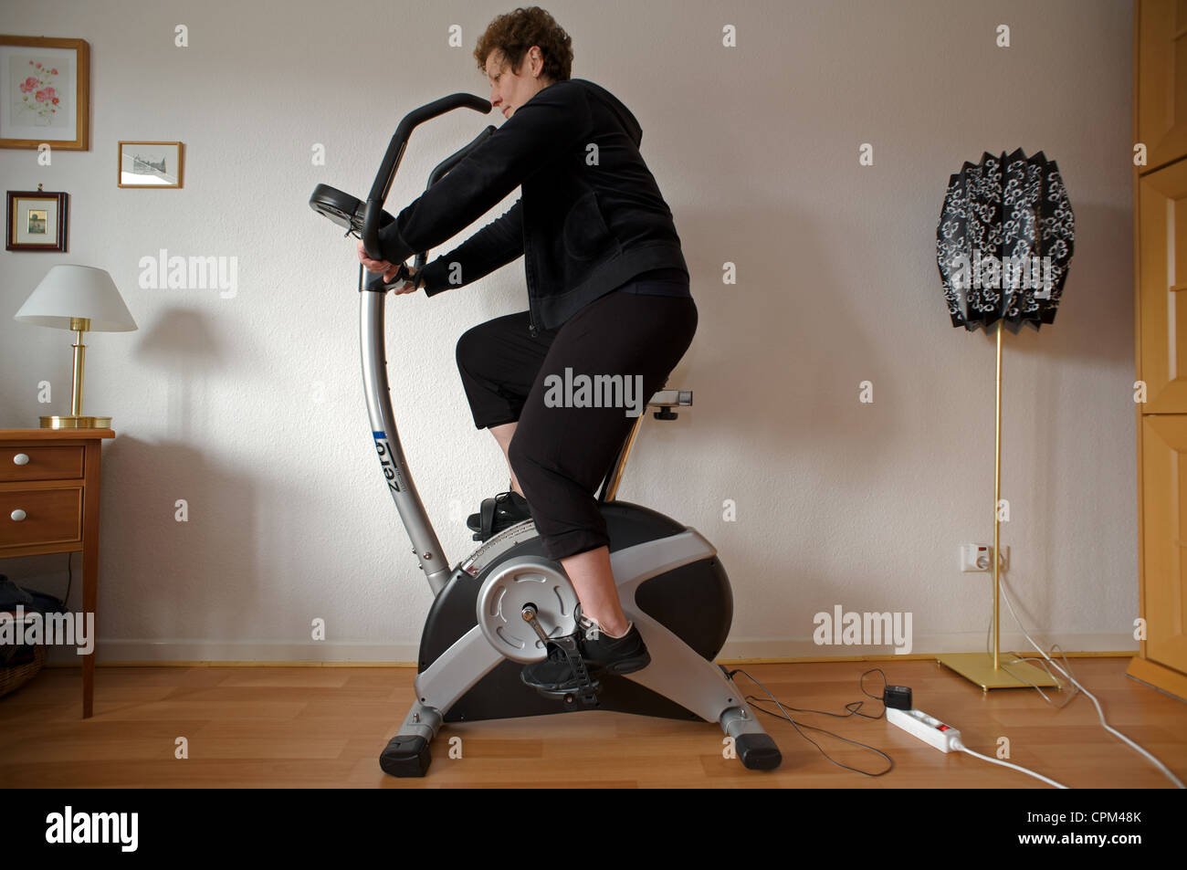 Frau zu Hause auf Heimtrainer Stockfoto