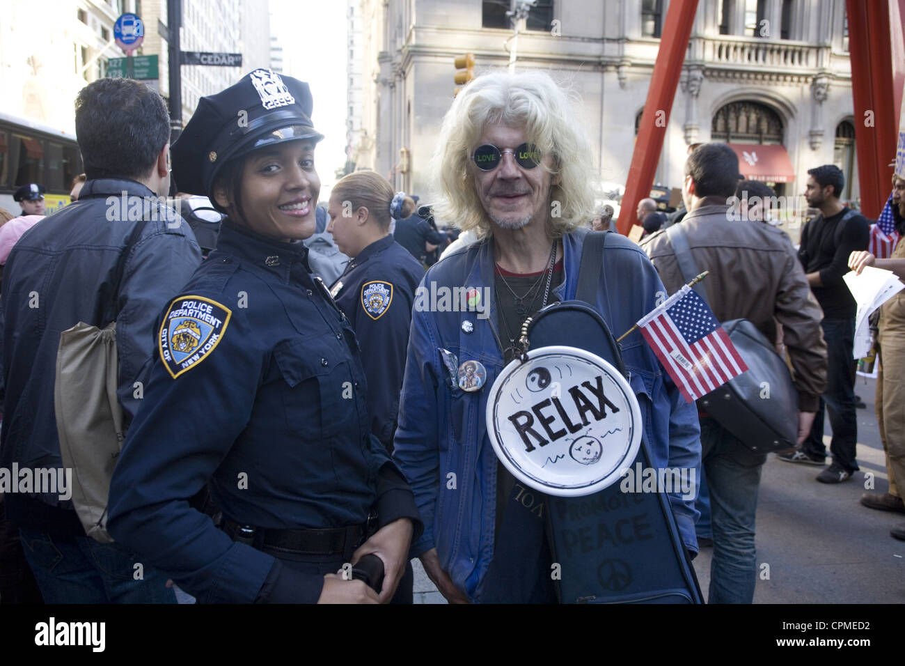 Wall-Street-Demonstrator steht für ein Foto mit einem NYPD Offizier an Zuccotti Park, aka Liberty Square in Manhattan zu besetzen. Stockfoto