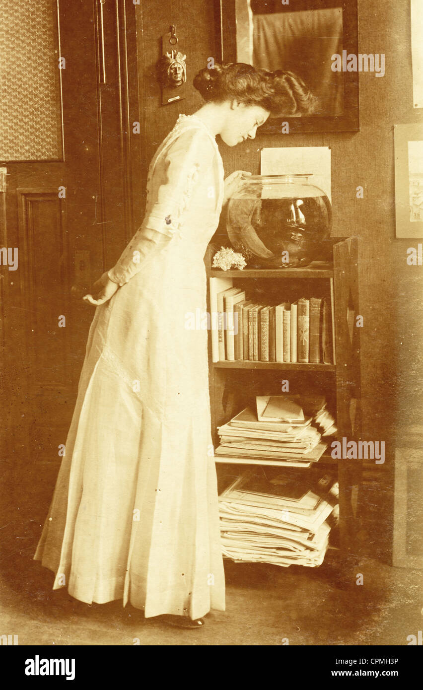 Attraktive junge Frau Peering in Goldfischglas Stockfoto