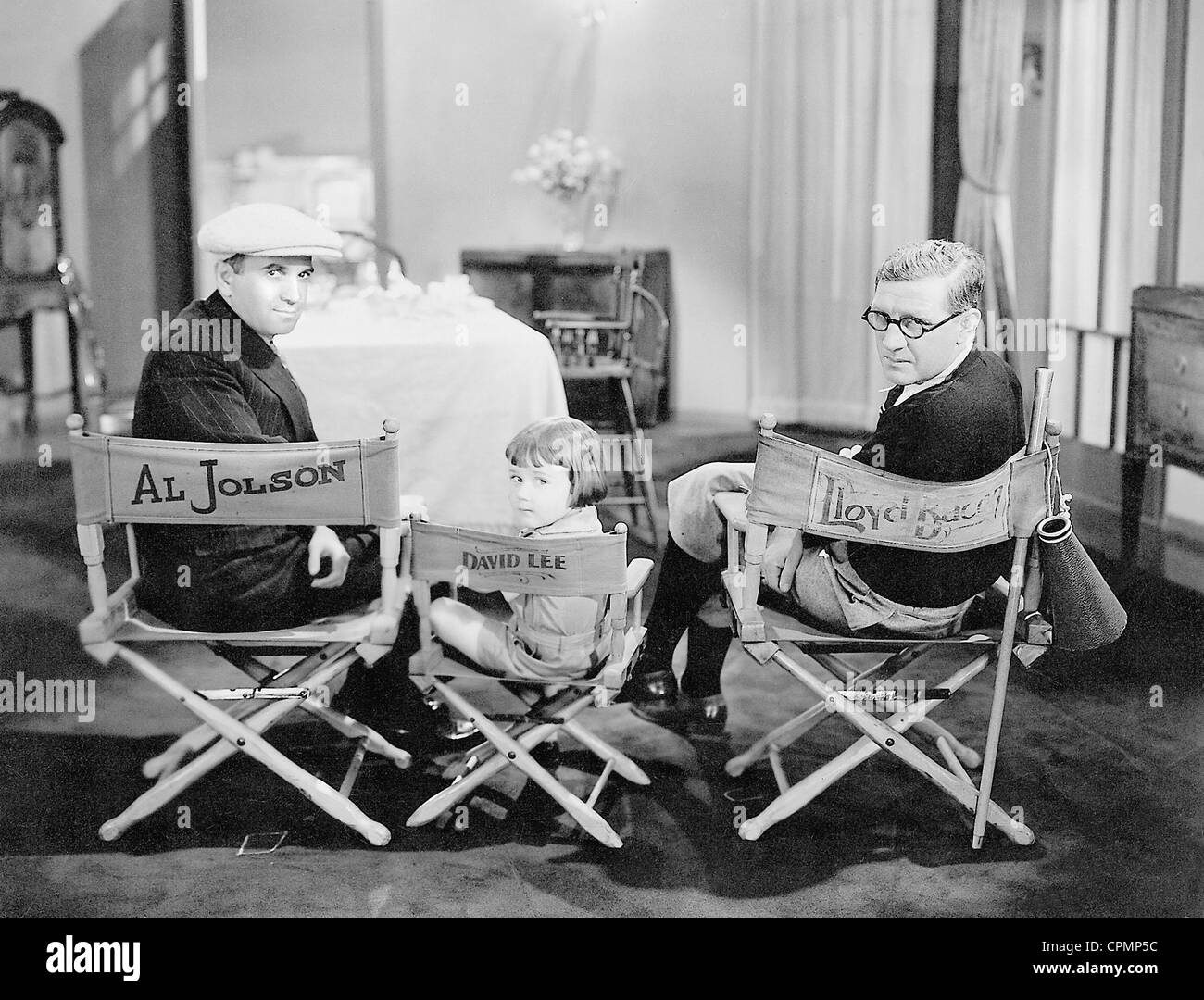 Al Jolson, Davey Lee und Lloyd Bacon während einer Pause bei Dreharbeiten für "Sagen, dass es mit Liedern", 1929 Stockfoto