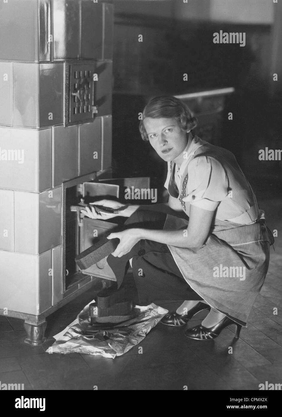 Eine Frau heizt Backofen, 1936 Stockfoto