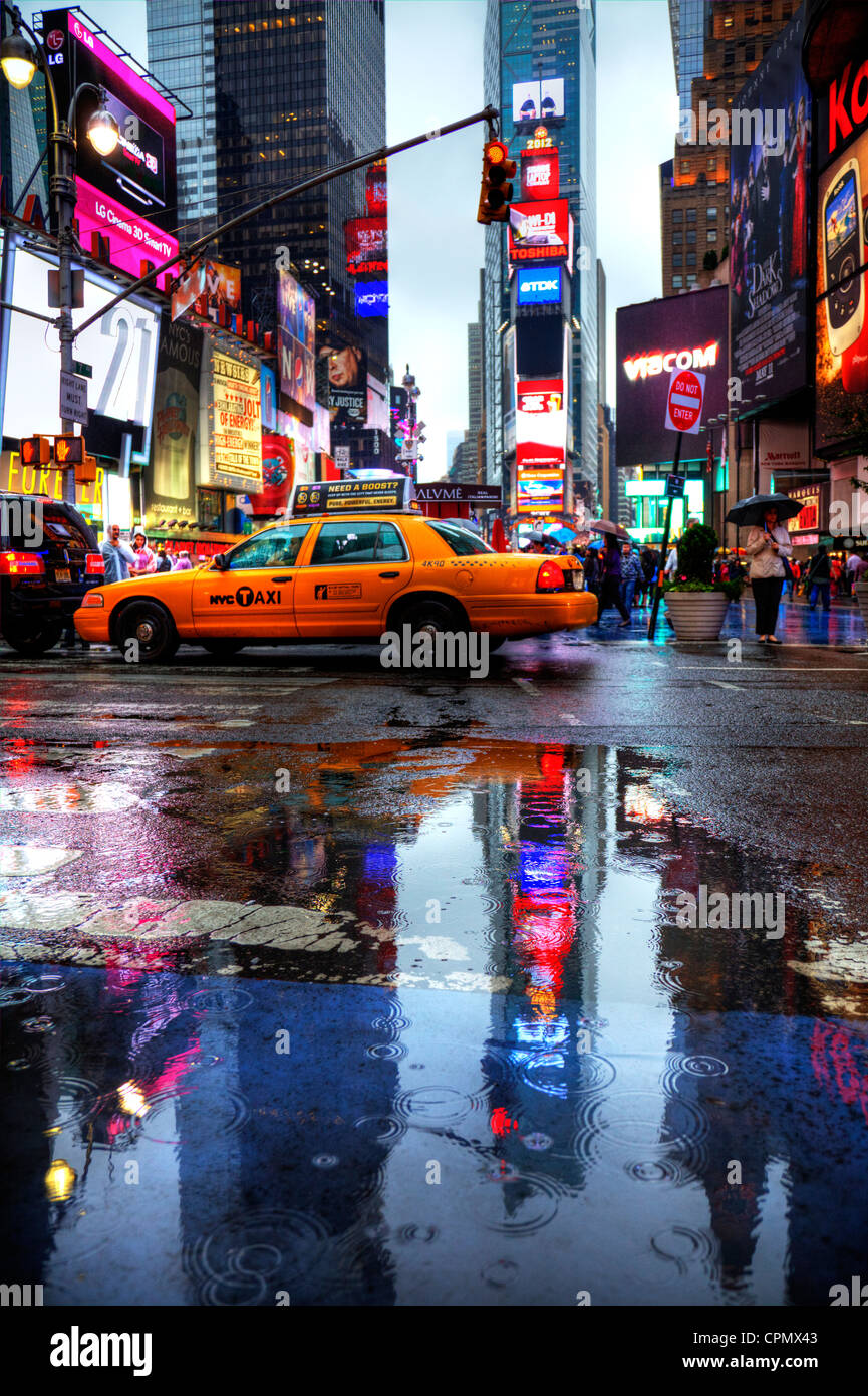 Legendären New York gelbe Taxis auf dem Times Square in Manhattan. Reflexionen aus dem Regen und Pfützen Times Square New York Zeiten Stockfoto