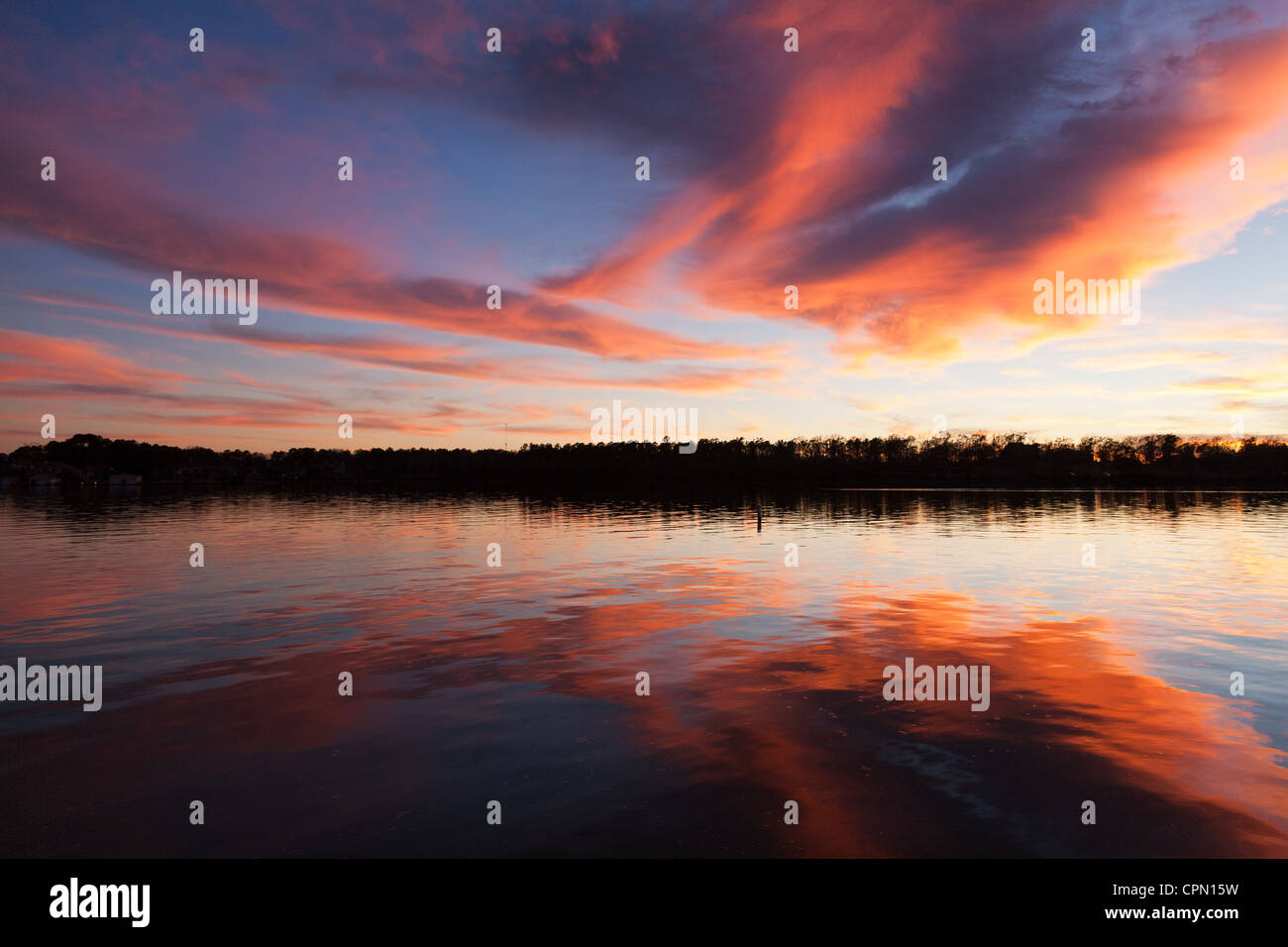 Conroe, Texas: Die stillen Wasser des Lake Conroe reflektieren einen flammenden Himmel am Ende des Tages. Stockfoto