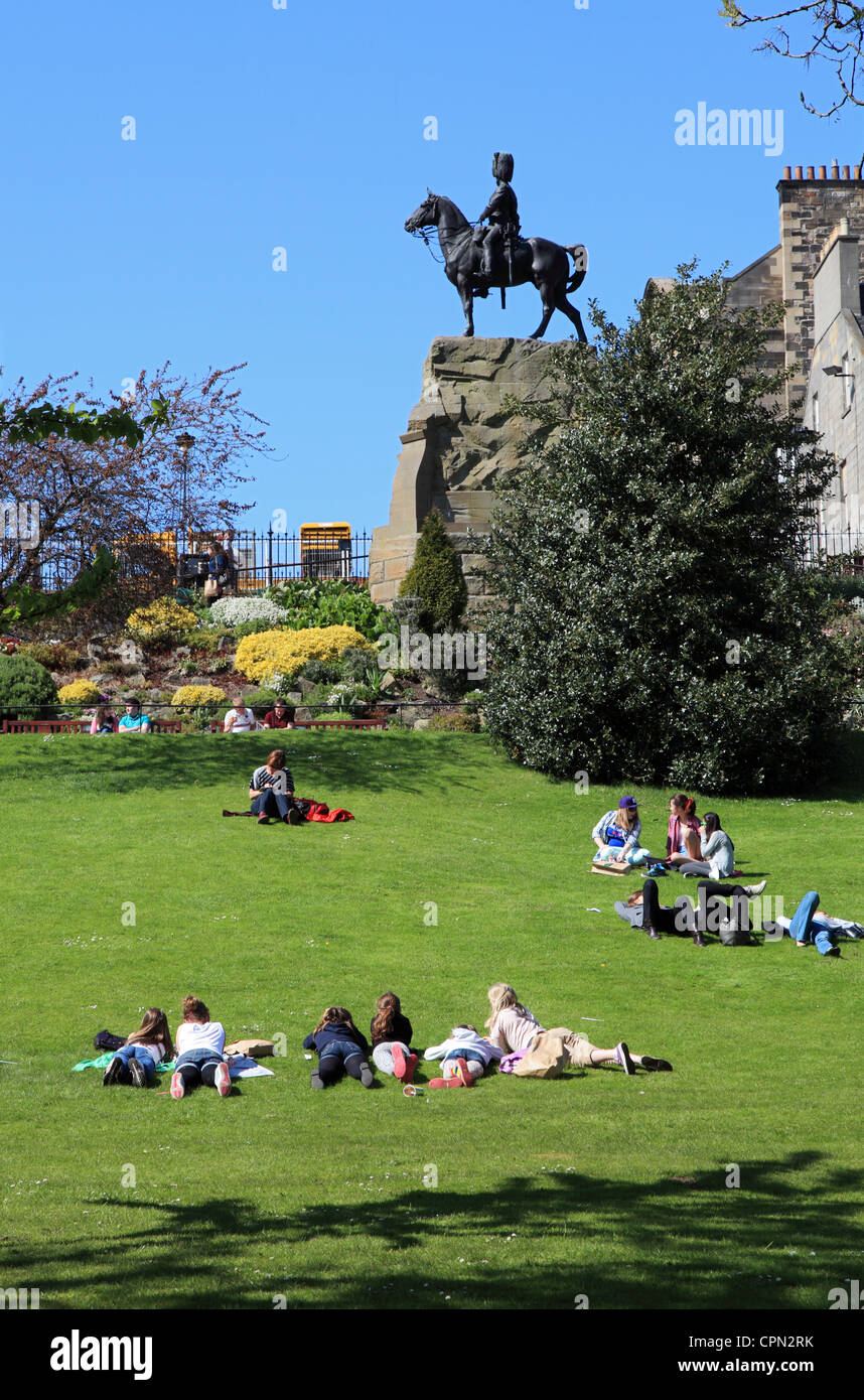 Junge Menschen, entspannen und genießen Sonnenschein in Princes Street Gardens, Edinburgh Scotland UK Stockfoto