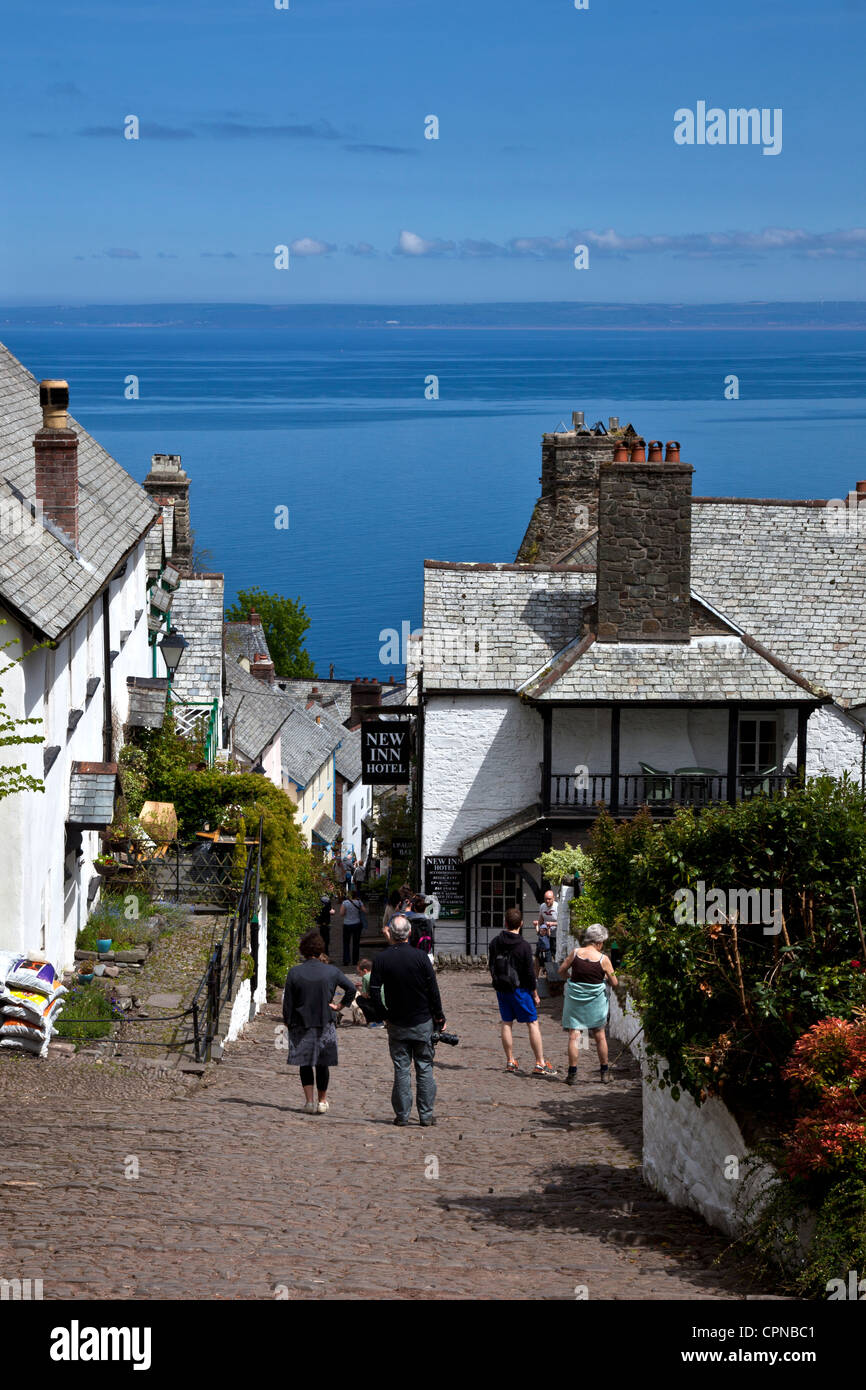 Urlauber, die nach oben und unten den steilen Weg zu Fuß vom Hafen in Clovelly mit View of Bristol Channel im Hintergrund Stockfoto