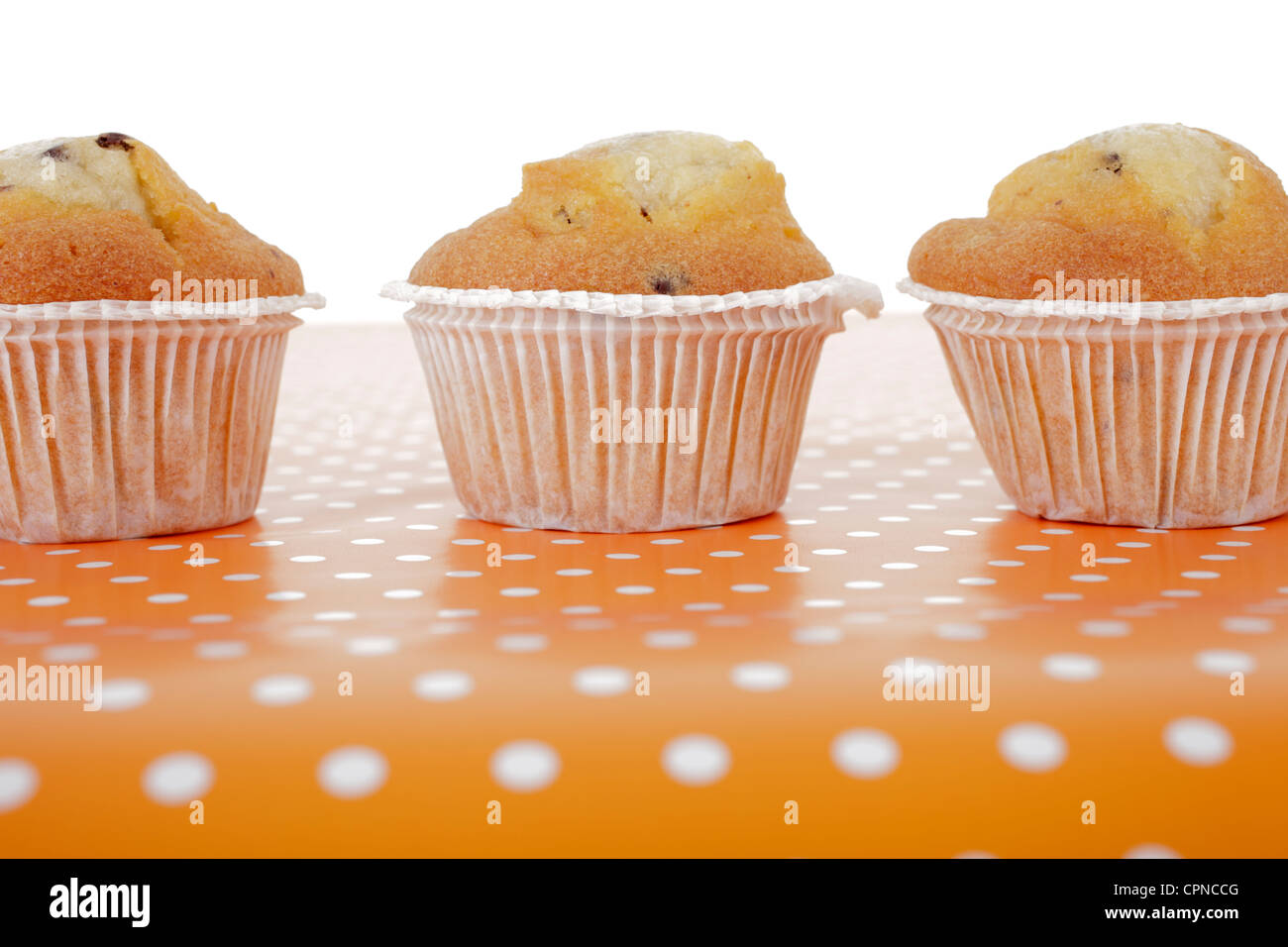 Drei hausgemachte Muffins auf einem Punkt Hintergrund. Stockfoto