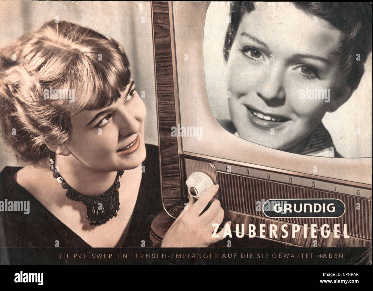 Sendung, Fernsehen, Frau mit Fernsehgerät, Hand am Netzschalter, Werbung für Grundig Fernsehgerät 'Zauberspiegel', auf der Leinwand: Die damals sehr beliebte TV-Sprecherin der NWDR Angelika Feldmann, illustriert: Tischset 335 mit 43 Zentimeter Bildschirmgröße, Chassis: Exotische Hölzer, Originalpreis 1955: DM 768, Deutschland, 1955, zusätzliche-Rechte-Clearenzen-nicht verfügbar Stockfoto