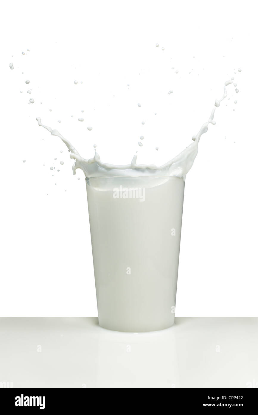 Milch spritzt aus dem Glas Stockfoto