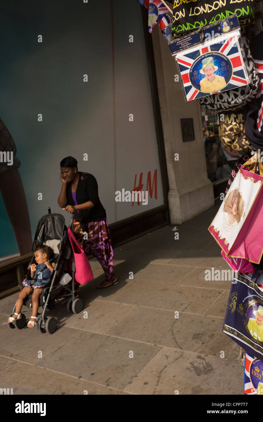 Mutter und Kind geht royal Souvenir waren in der Oxford Street in der Woche eine lächelnde Dame Diamant-Jubiläum feiern. Stockfoto