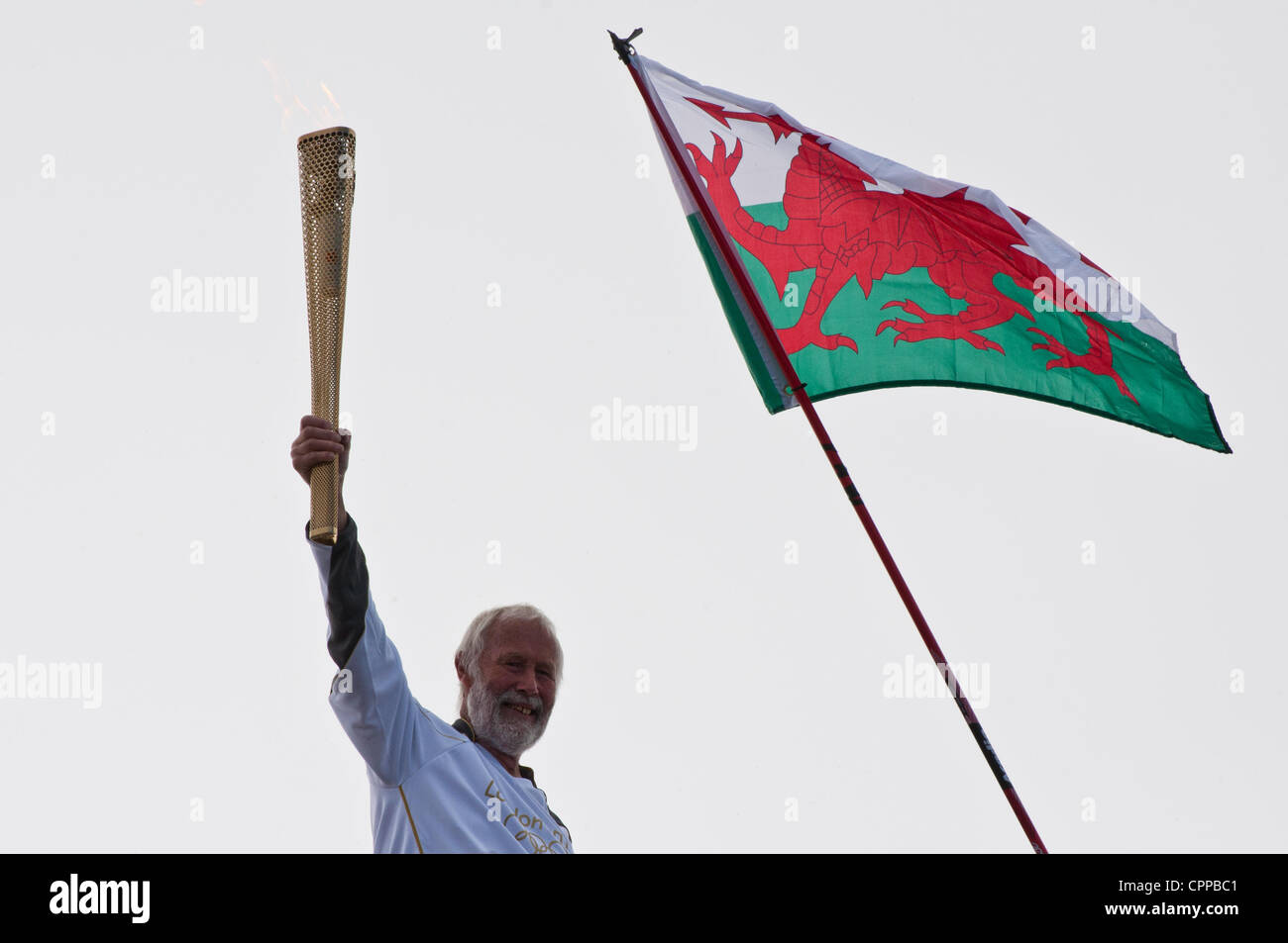 Bekannte Bergsteiger Chris Bonington hält die Olympische Fackel für die Olympischen Spiele London 2012 empor über Mount Snowdon, Wales, UK. Dies ist die Fackel höchsten Venture in Großbritannien 29. Mai 2012. Stockfoto