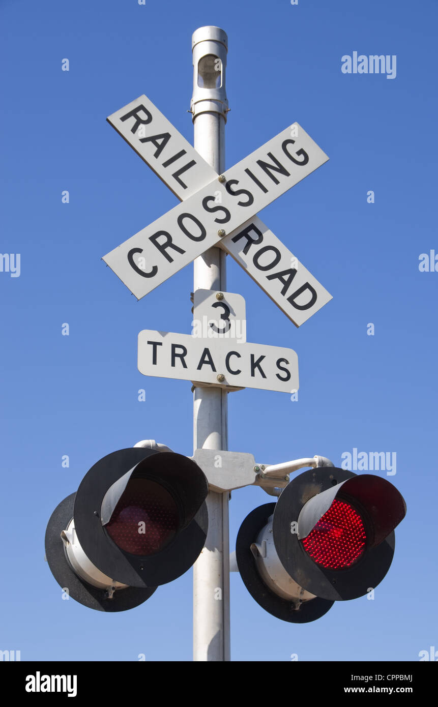 3 Tracks Eisenbahn Kreuzung Zeichen mit blinkenden roten Leuchten Stockfoto