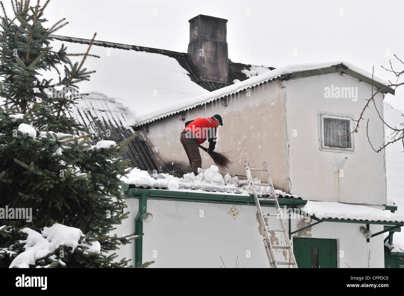 Mann entfernen Schnee vom Dach, Region Masowien, Polen Stockfoto