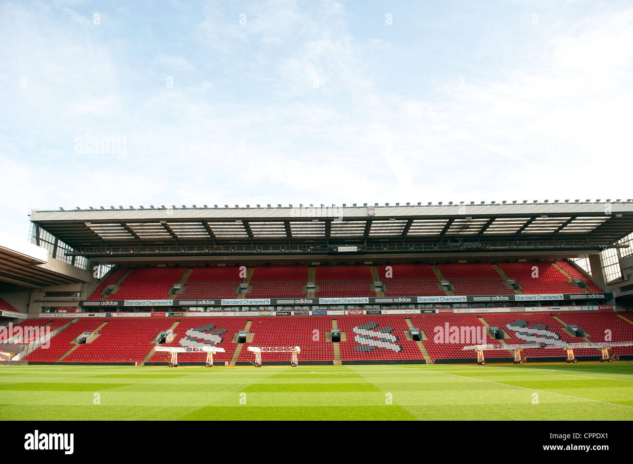 Stände und Tonhöhe an der Anfield Road leer. Satz von UV-Leuchten sind auf Spielfeld Graswuchs fördern. Stockfoto