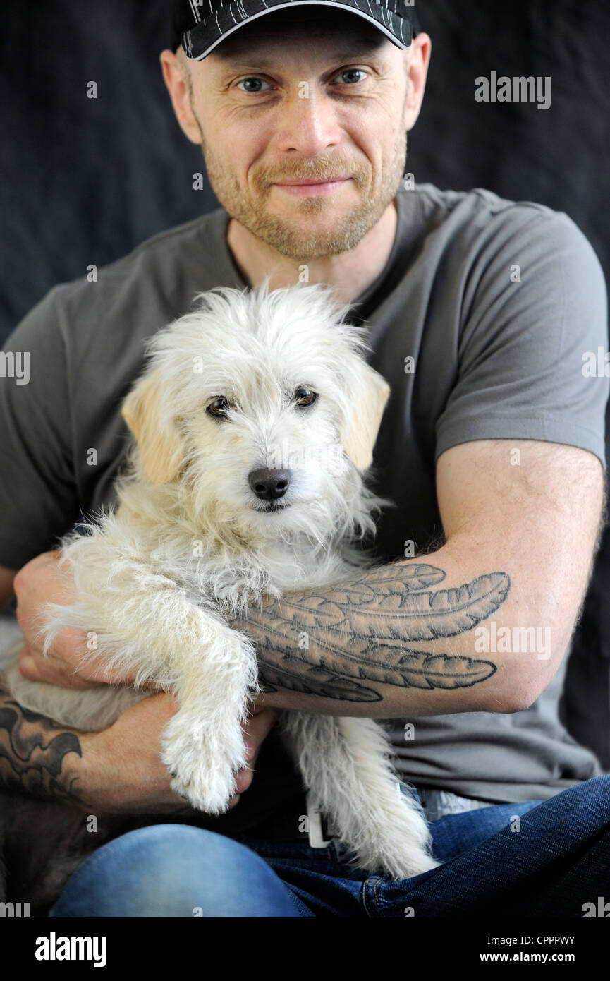 Mann mit Tattoos und einen süßen Hund. Stockfoto