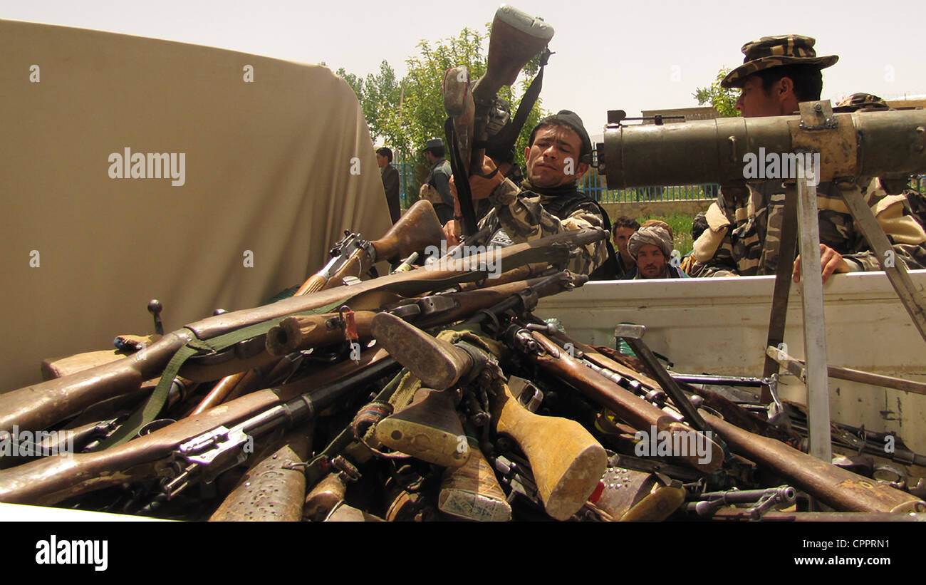 Ein afghanischer Soldat Lasten Waffen übergeben von ehemaligen Taliban-Kämpfer während einer Wiedereingliederung Zeremonie an den Landeshauptmann Verbindung 28. Mai 2012 in Ghor, Afghanistan. Stockfoto