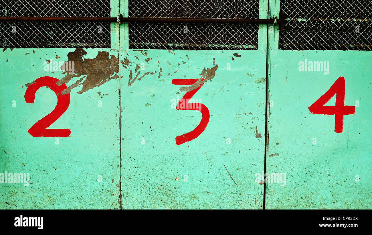rote Zahlen 2, 3 und 4 auf Petrol Türen von Hand bemalt Stockfoto