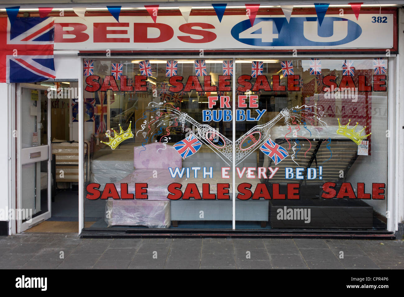 Tage, bevor die Königin Diamond Jubilee Wochenende, eine Anzeige der patriotischen Fahnen und Werbeartikel Verkauf bietet kostenlosen Sekt schmücken die Fenster eines Bettwaren-Shop in Süd-London. Stockfoto