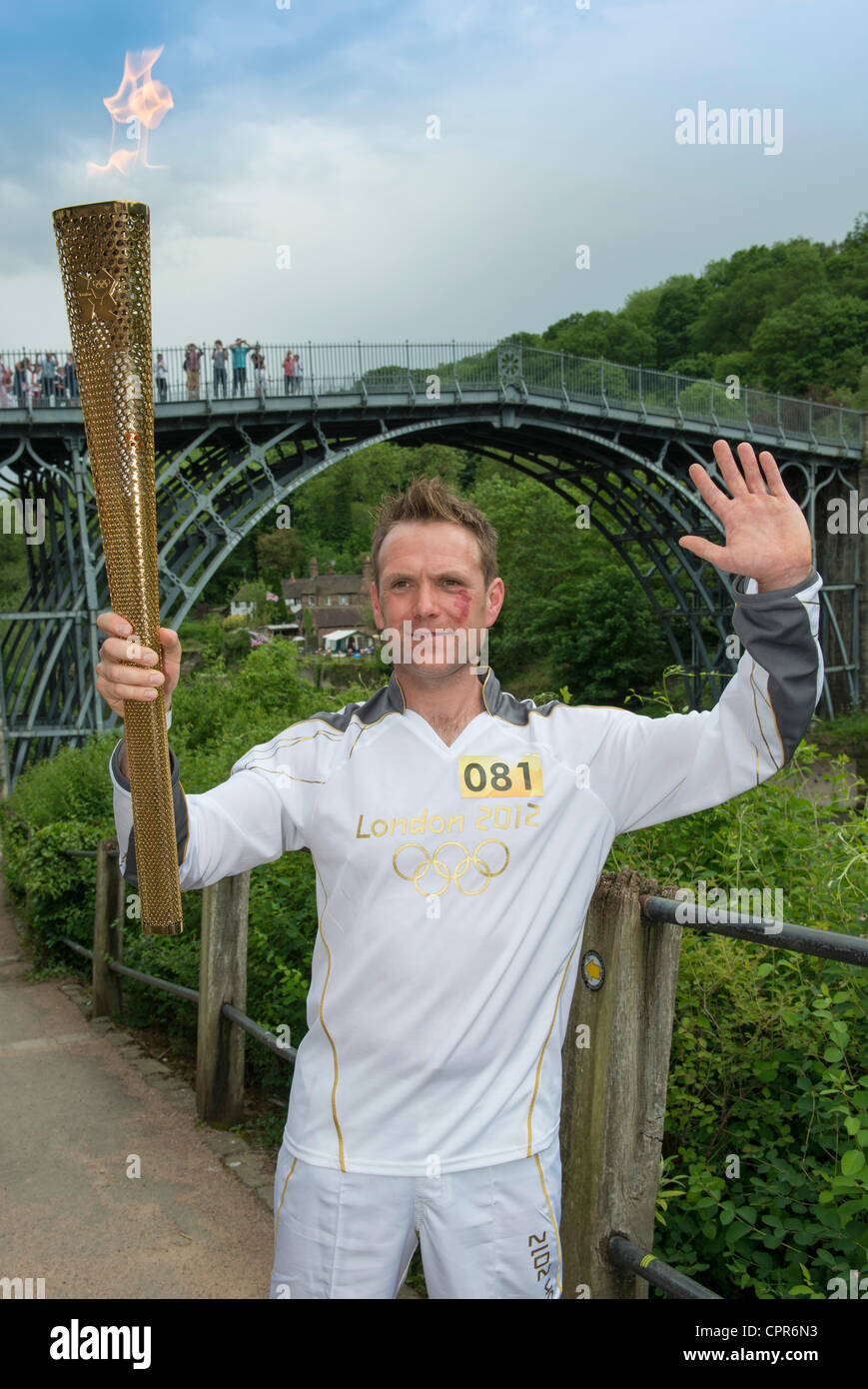 Ironbridge, Telford, Shropshire, UK. Lyndon Flavell 37 aus Wolverhampton, trägt die Olympische Fackel hinter der eisernen Brücke am Mittwoch 30. Mai im Rahmen des Olympischen Fackellaufs. Stockfoto