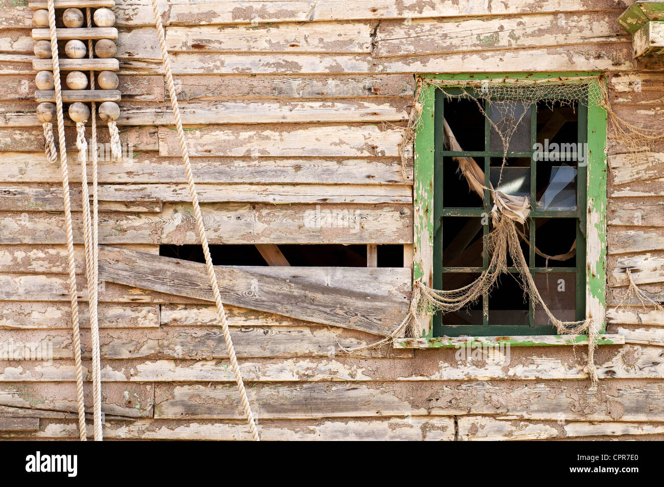 Wand mit einem alten grünen farbigen Holzfenster aufgegeben. Stockfoto