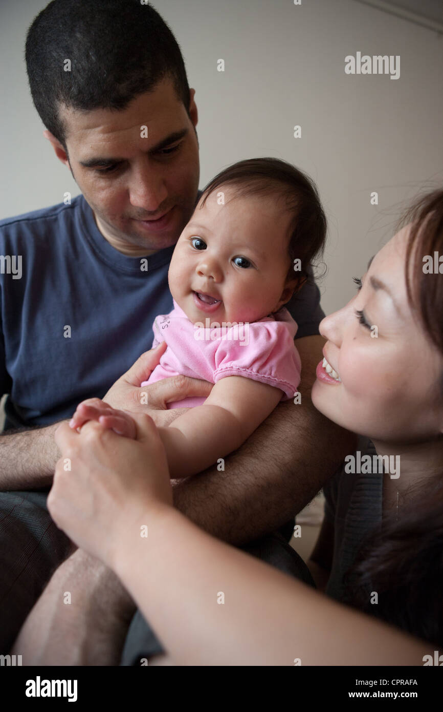 Japanische Mutter und ethnisch gemischten Papa halten vier Monate altes Babymädchen zu Hause. Stockfoto