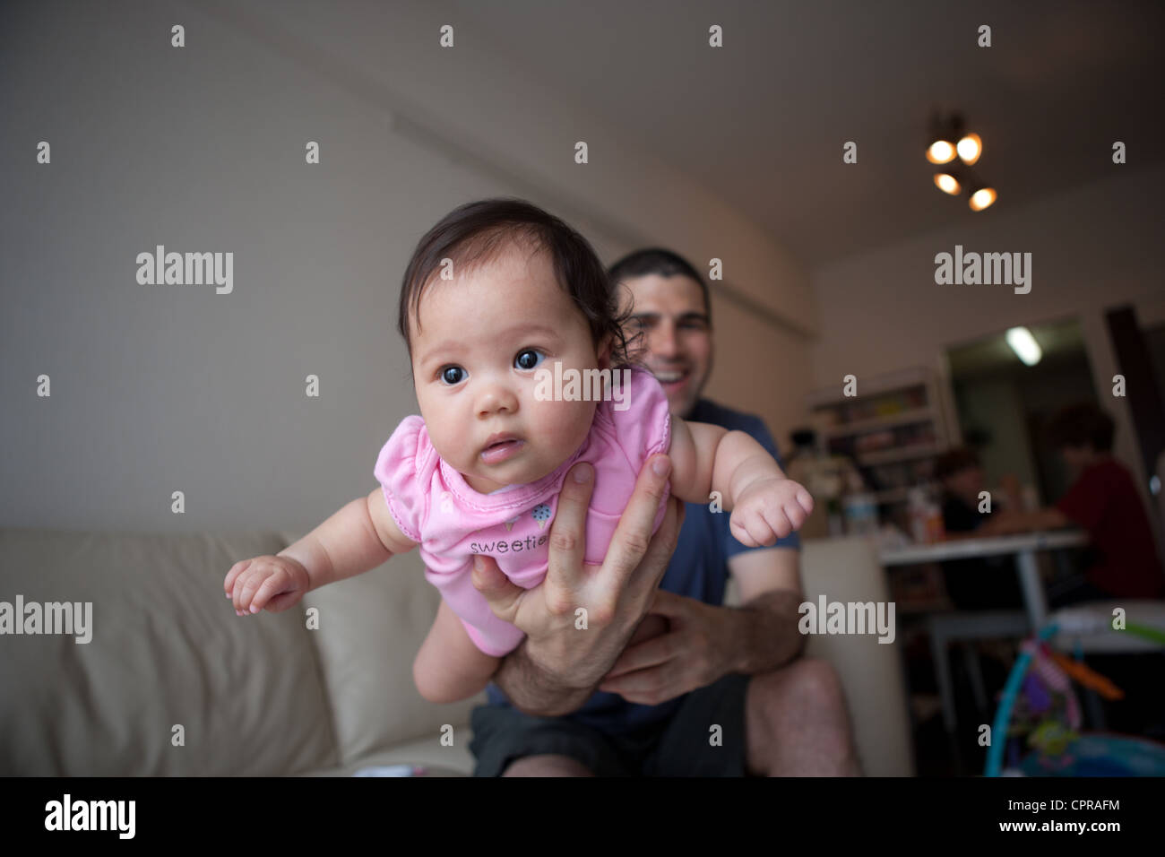 Angst vor amerikanischen vier Monate alten Baby Japanerin in des Vaters Armen fliegen. Stockfoto