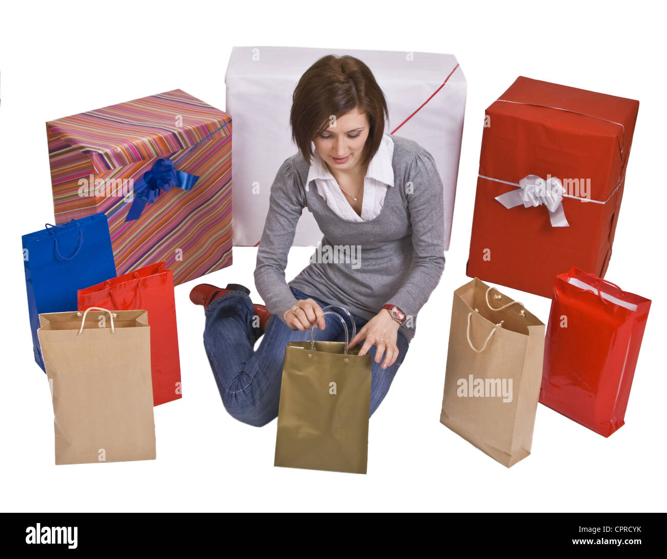 Frau, umgeben von vielen Geschenke, die auf der Suche in einer Tasche. Stockfoto