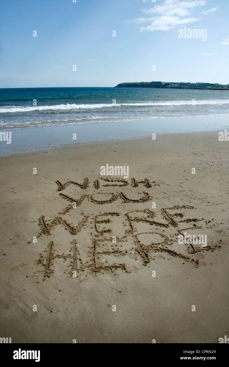 Nachricht in den Sand am Strand, "Wish you here were" geschrieben. Stockfoto